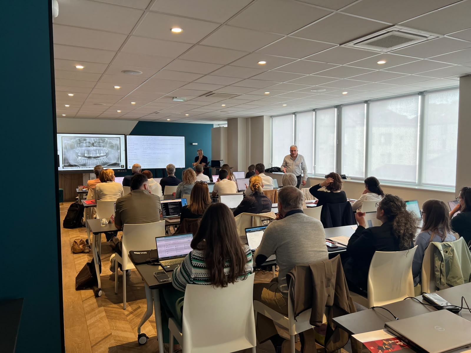 Salle de formation ADIA : analyse d’une radiographie panoramique et structuration du compte rendu, praticiens en travail sur leur ordinateur portable.